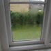 Misted double-glazed window with condensation trapped between the glass panes